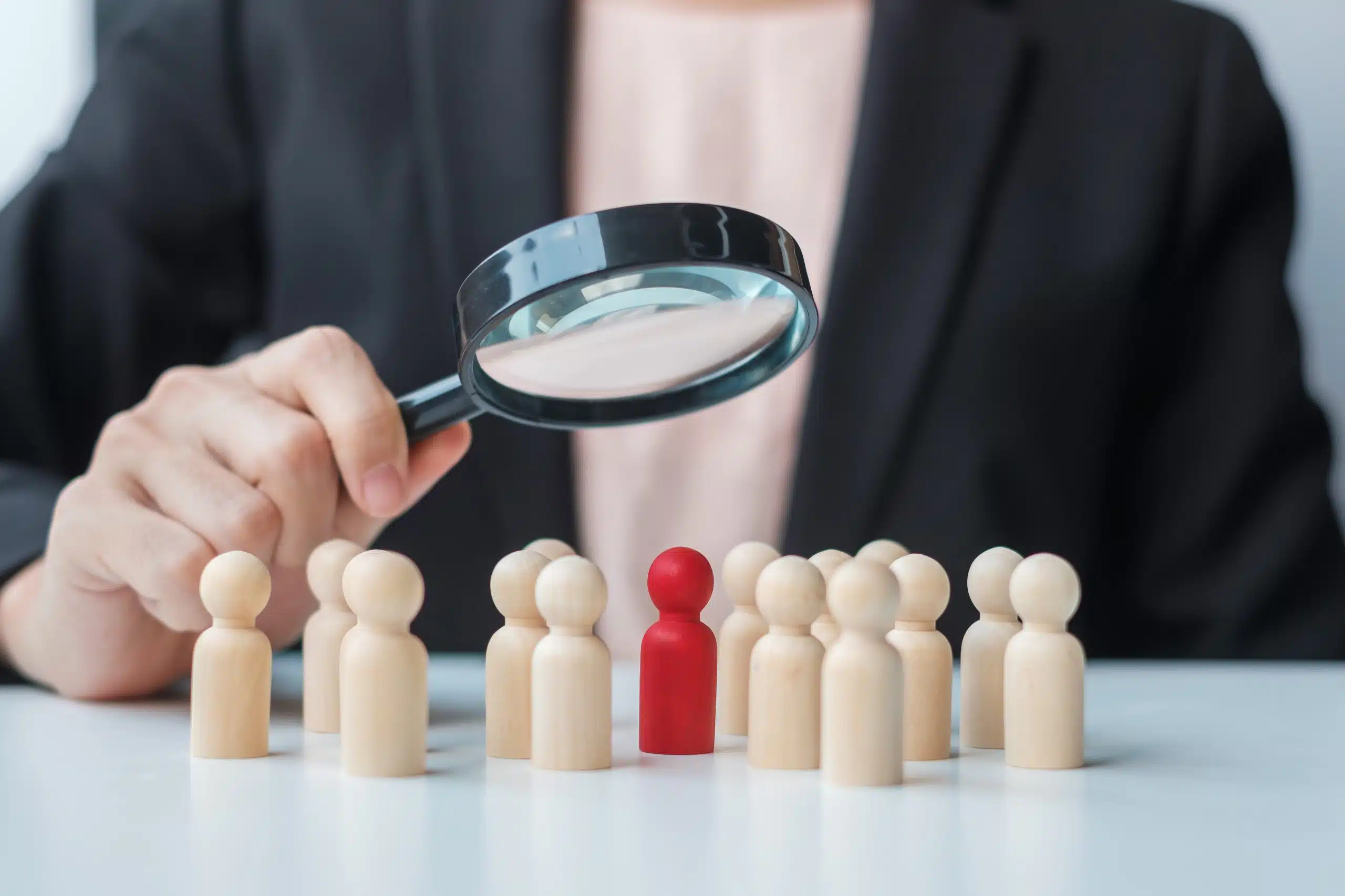 Magnifying glass focuses on red figure among others.