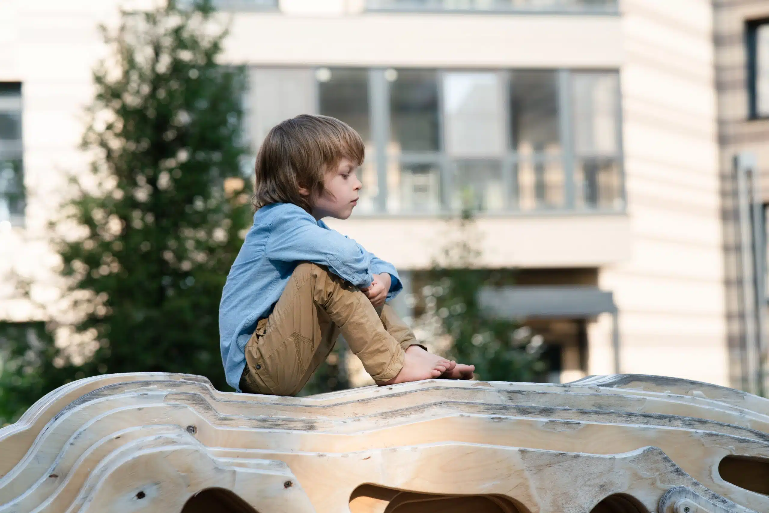 Child sitting on sculpture outdoors