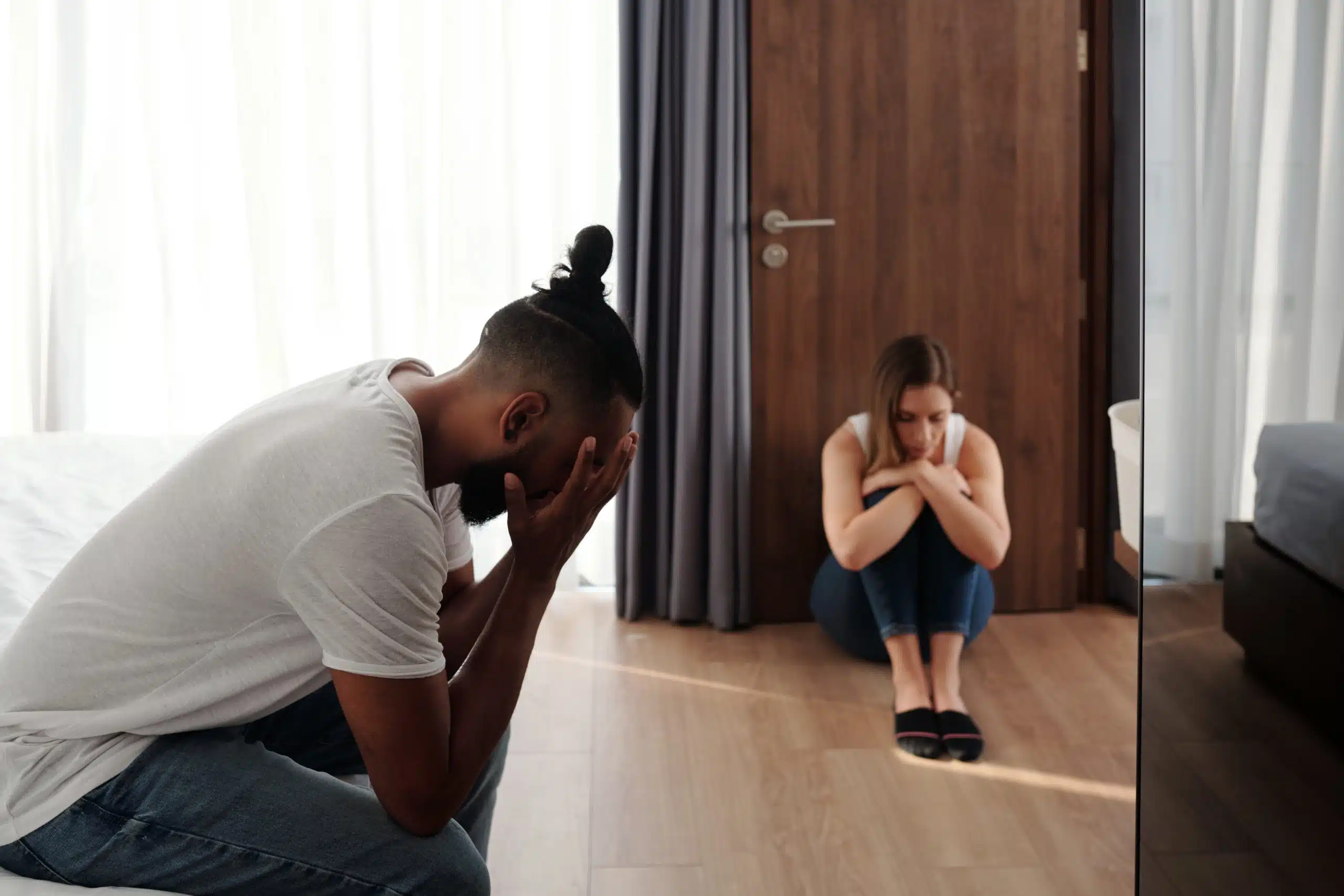 Couple experiencing emotional distress in bedroom.