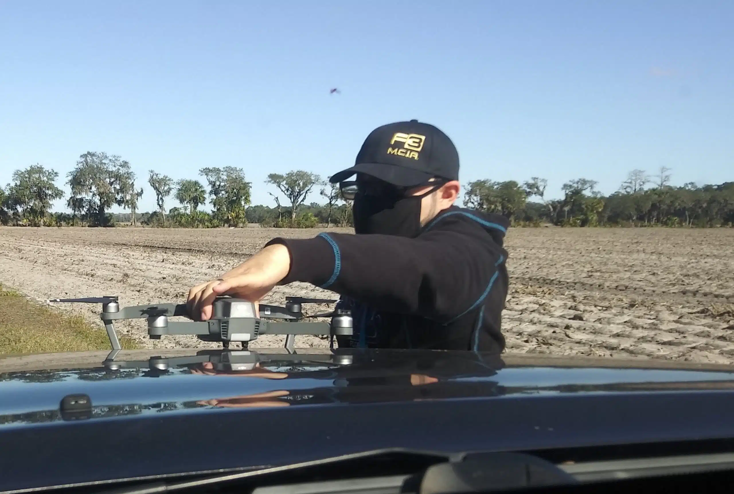 Person with drone in field setting.