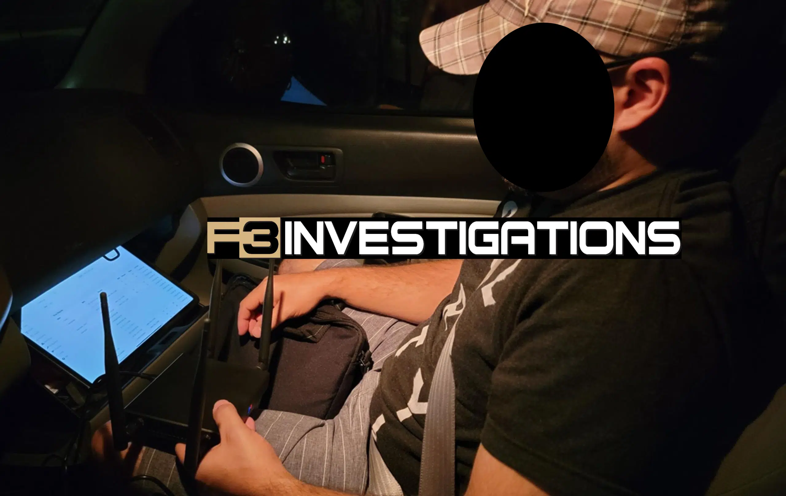 Person working inside a car with electronics.