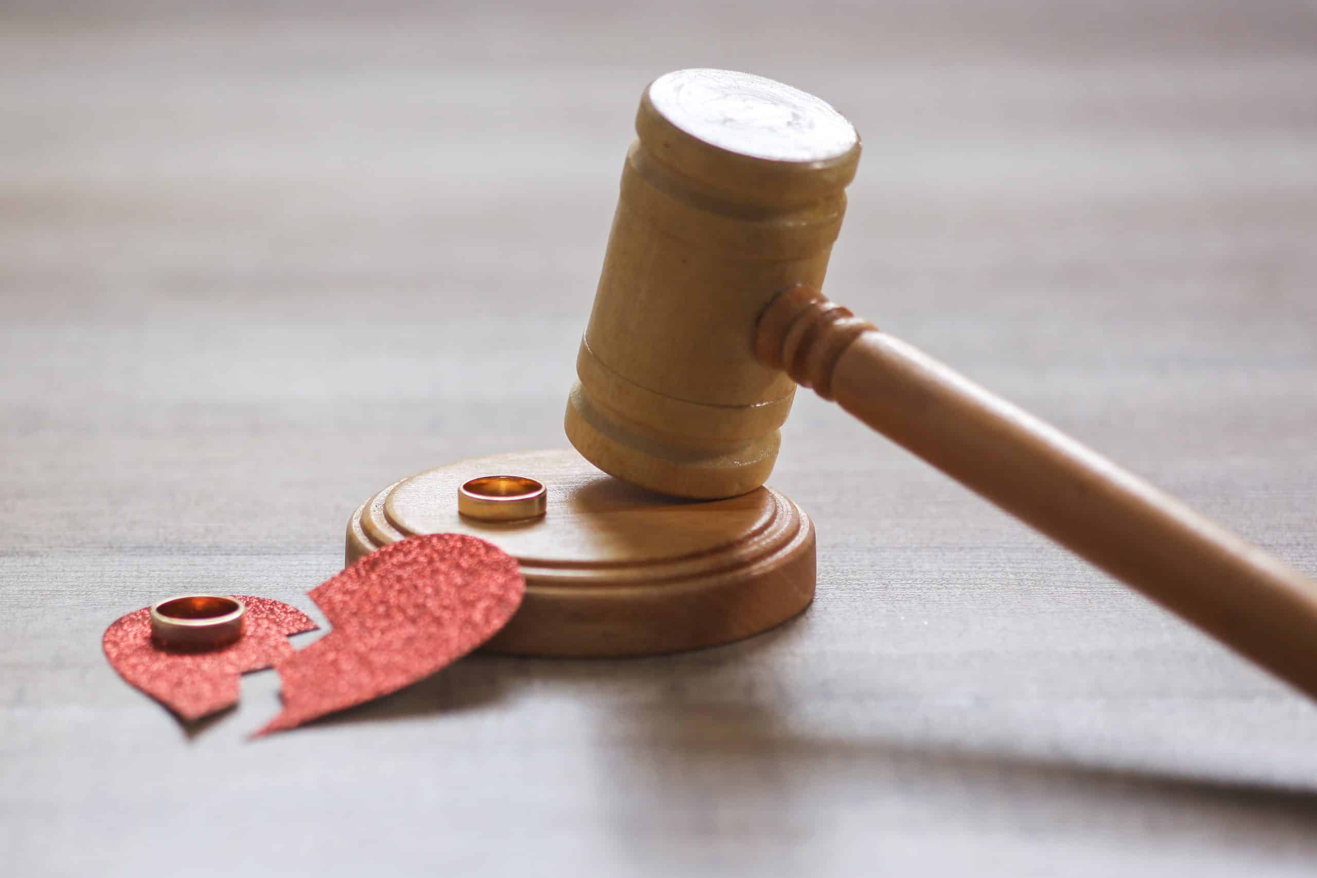 Gavel with wedding rings and broken heart symbol.