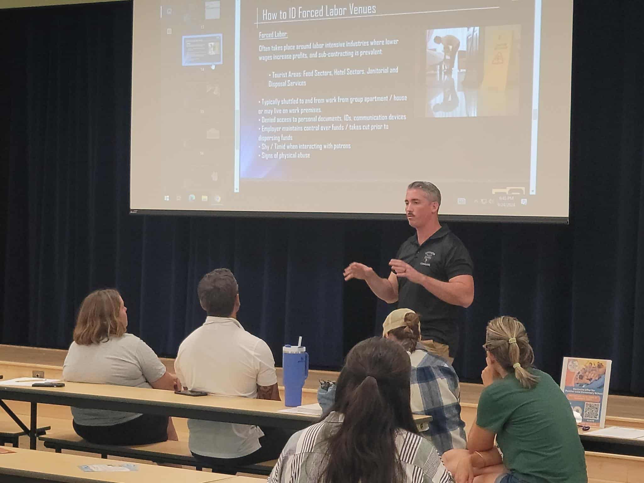 Instructor explaining forced labor indicators in class.