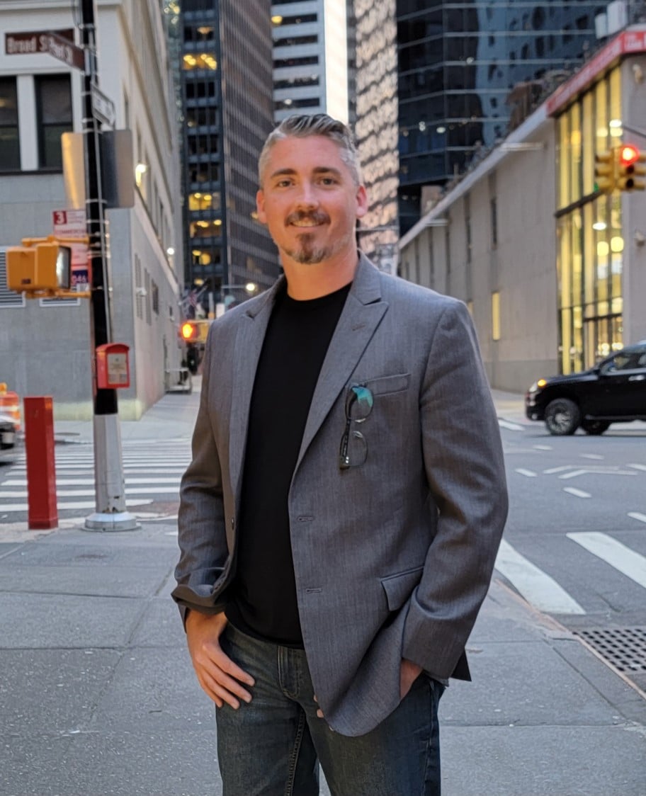 Man in city street with skyscrapers background.