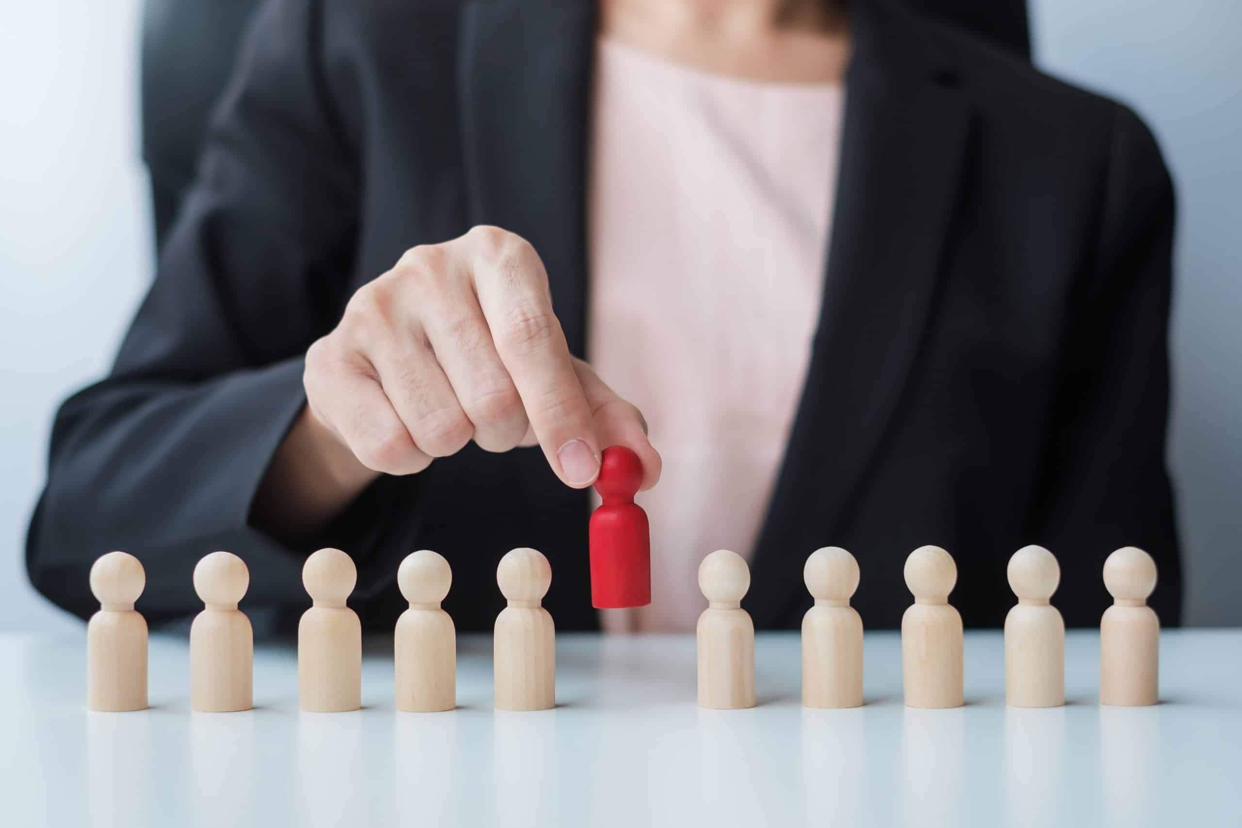 Person selecting red figure from wooden row