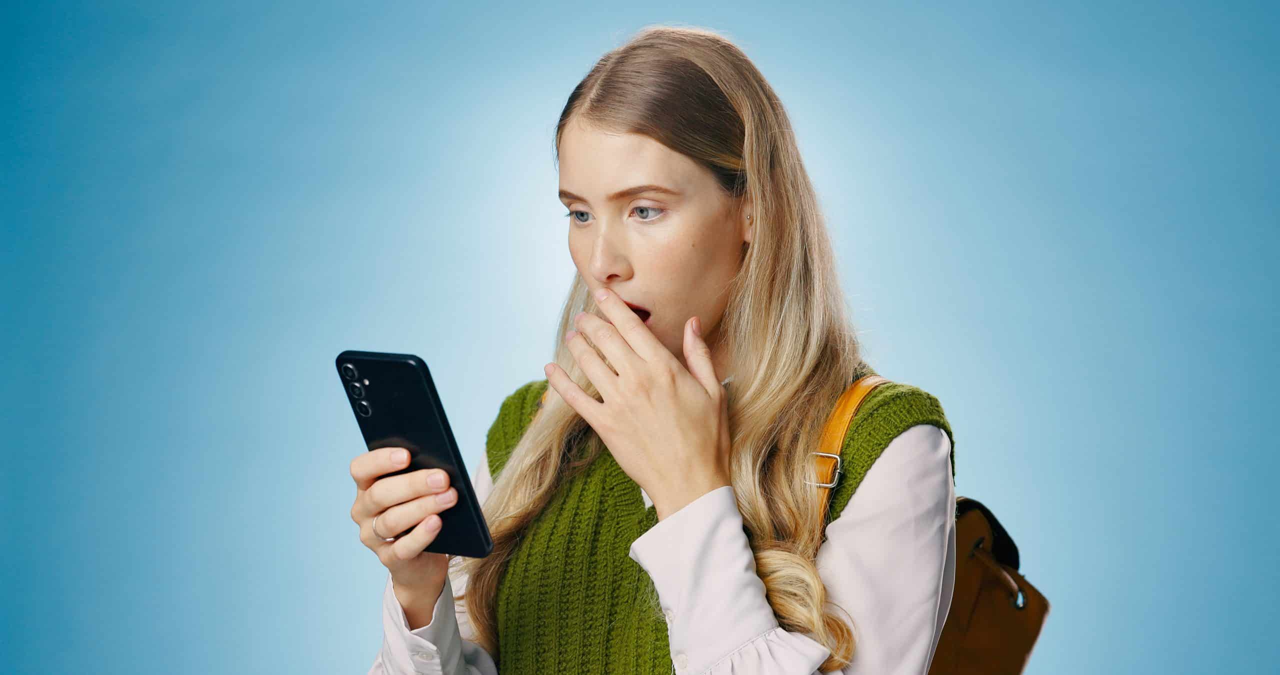 Woman surprised looking at phone screen.