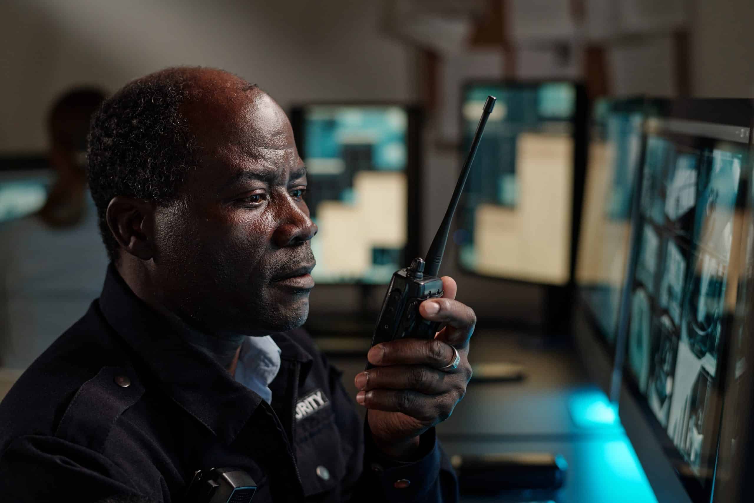 Security guard monitoring surveillance screens.